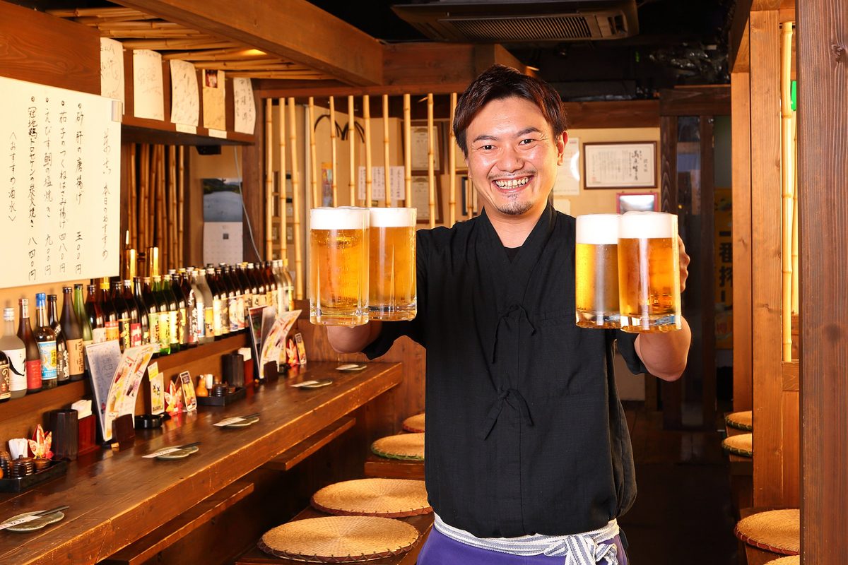 カウンターでビールを運ぶ店長